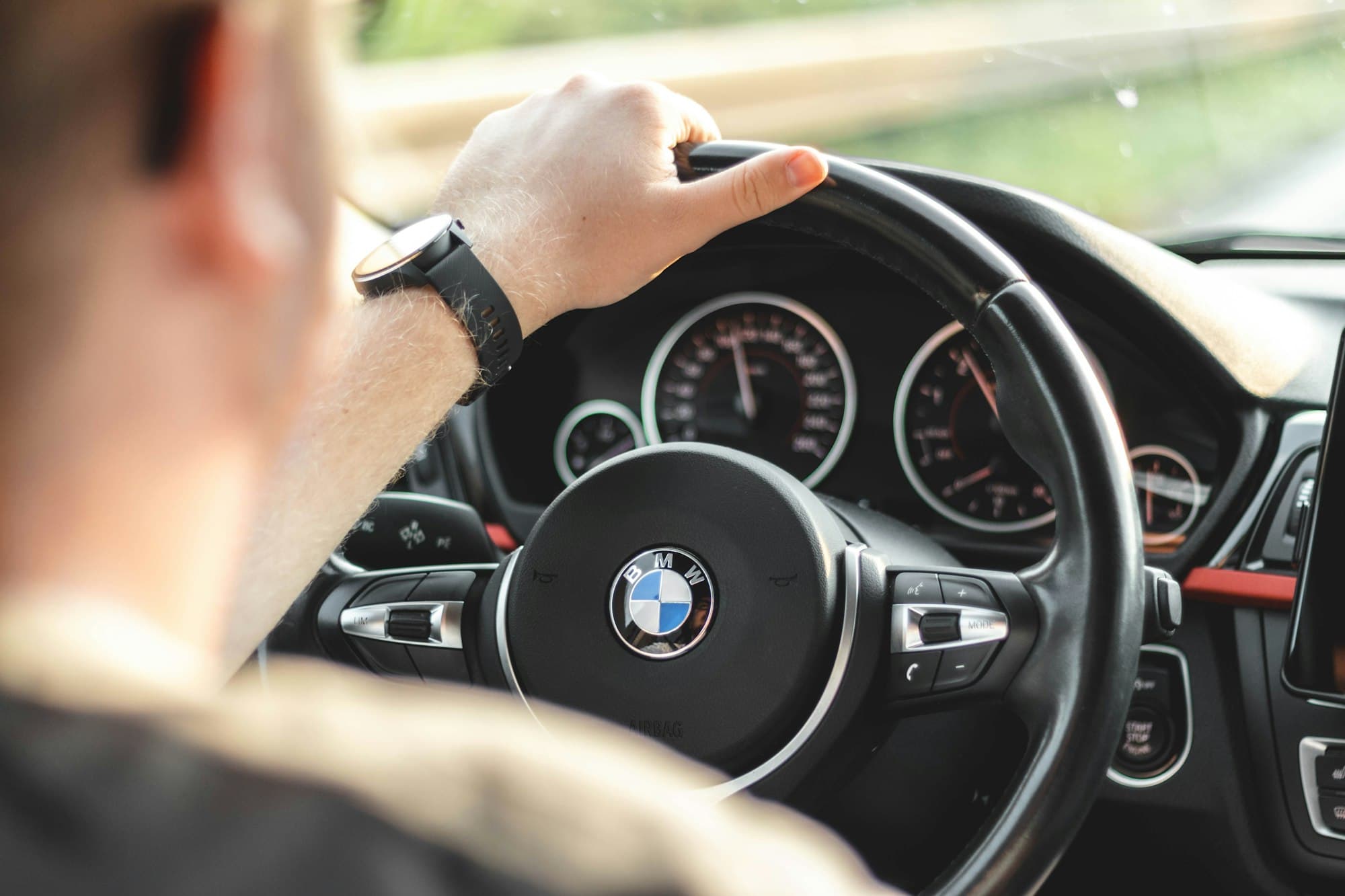 Otomatik vitesli otomobilde direksiyonu tutan el ve gösterge paneli